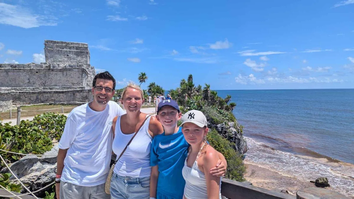 Guide explaining El Castillo to a small group on a Tulum archaeological zone walking tour, Tulum Mexico
