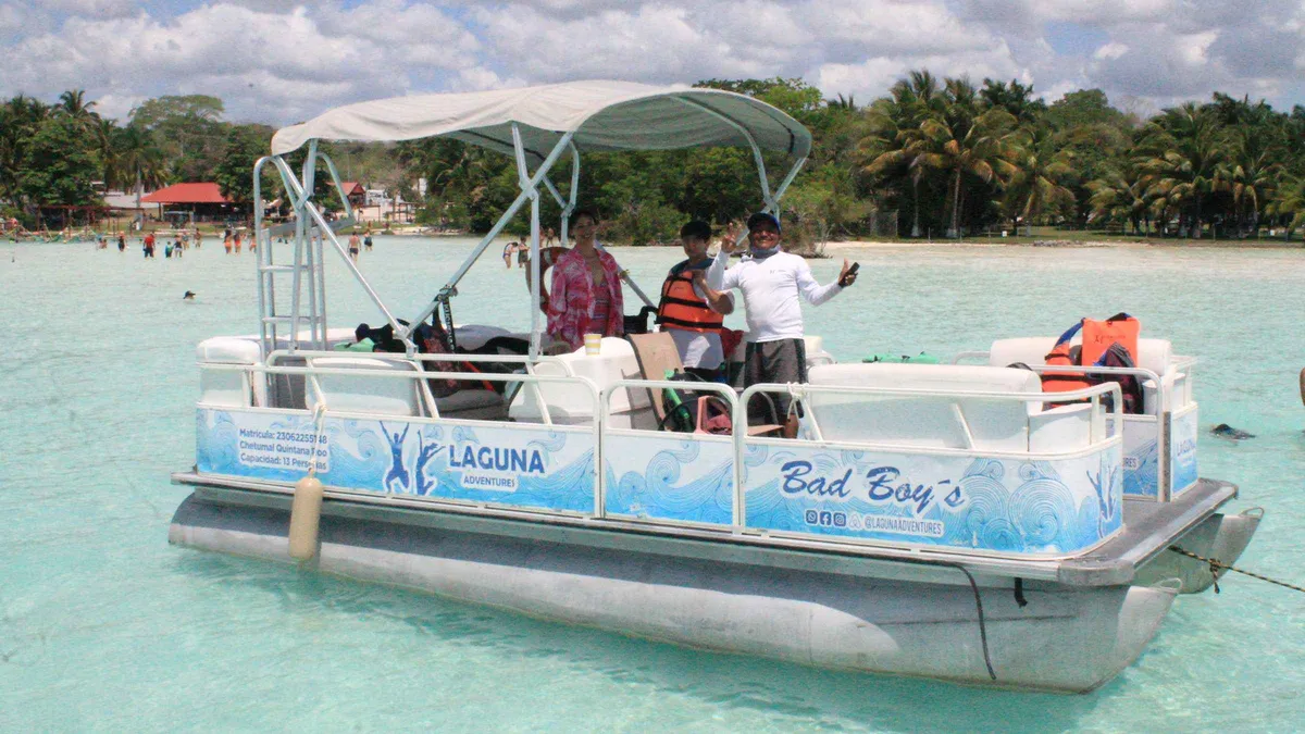 Pontoon boat anchored over pale shallows on the Lake of Seven Colours at Bacalar, Bacalar Mexico