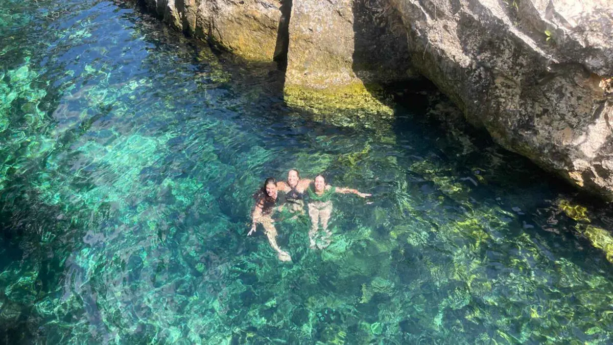 Light shaft falling into an open cenote on a three-cenote exploration tour, Tulum Mexico