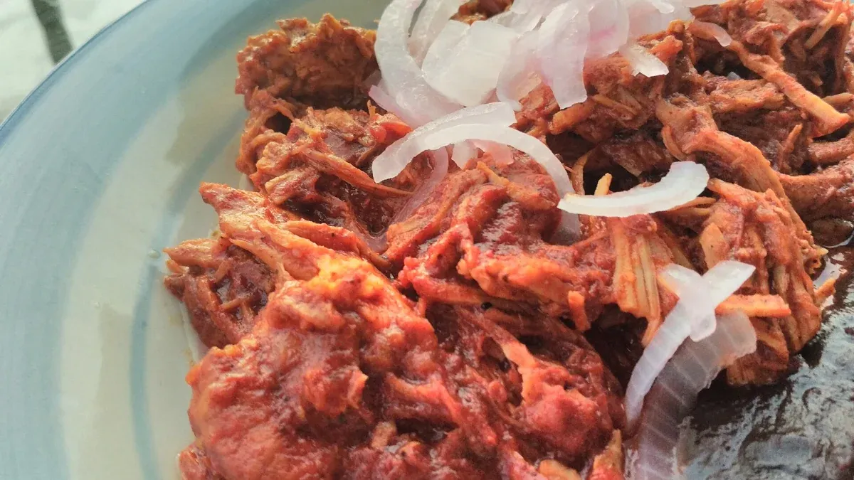 Cochinita pibil, the slow-roasted pork of the Yucatán served at loncherías in Tulum, Mexico
